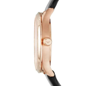 Side view of a rose gold ladies watch with black leather strap and textured crown
